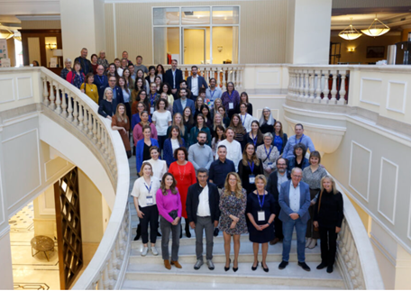 Photo showing the conference attendees stood on a sweeping white staircase
